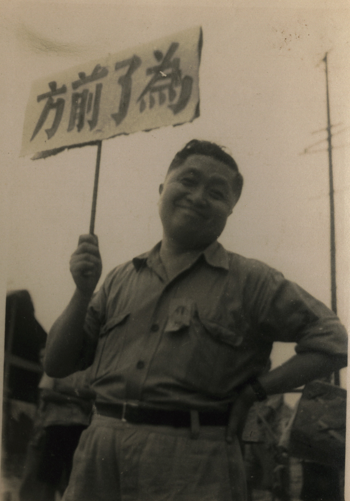 3 張光宇手舉“為了前方”標(biāo)牌，約1938年在香港.jpg